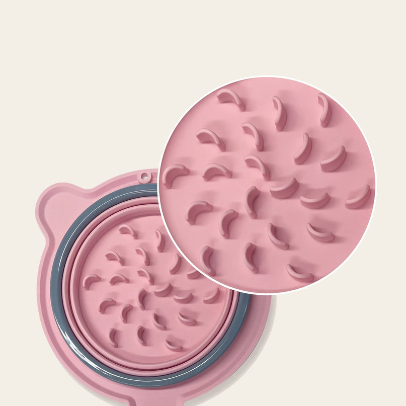 Gamelle pliable rose vue de dessus, avec ses éléments superposés et un disque à reliefs posé en biais