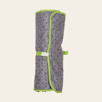 Tapis de fouille gris enroulé, bordé de vert et maintenu par une sangle