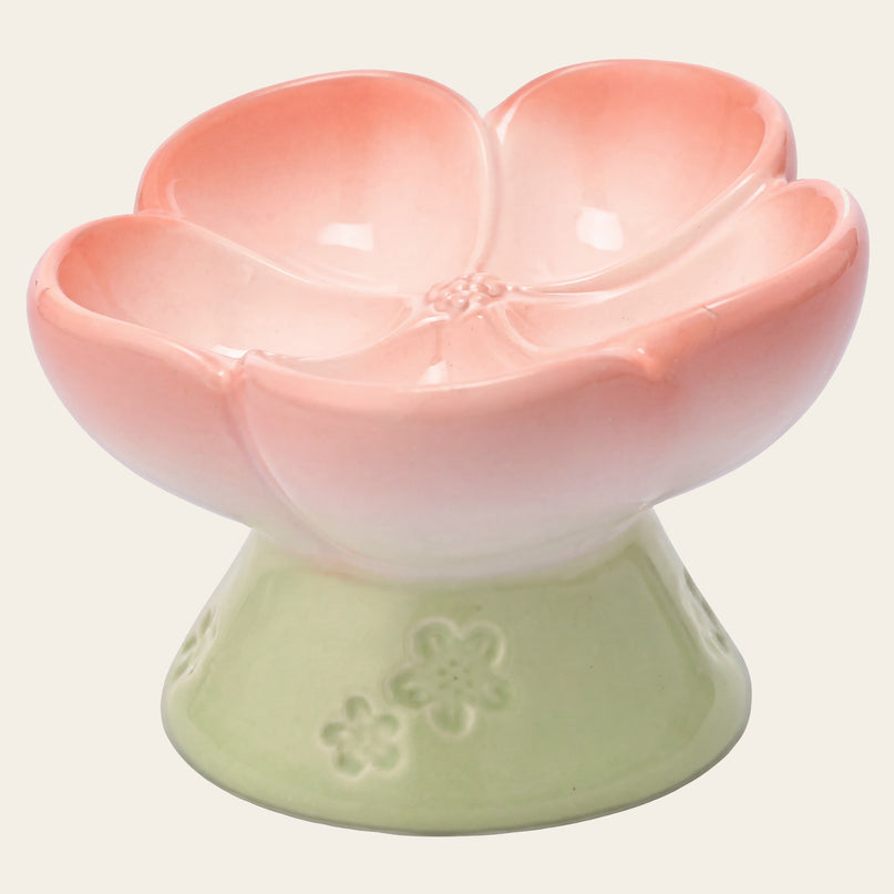 Gamelle en céramique en forme de corolle rose, vide, sur un pied vert clair